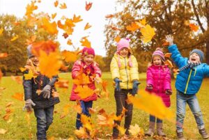 children-playing-with-leaves-autumn